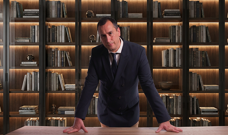 Guillaume PG Lamory at the front of a mural library, confident in his knowledge